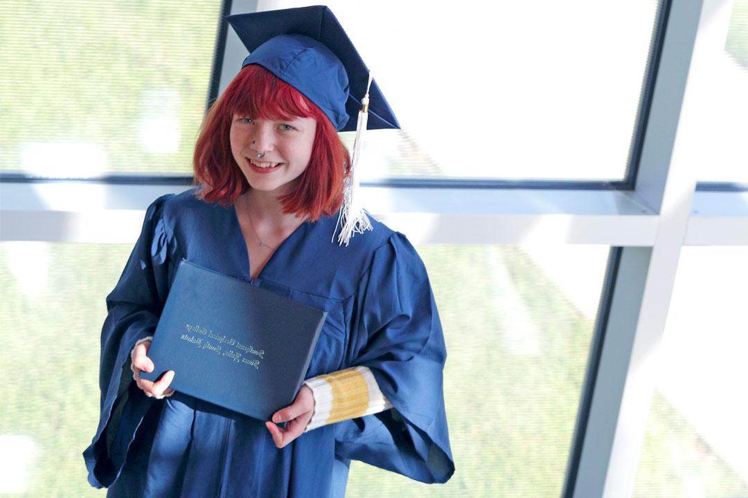 female graduate holding her diploma